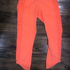LULULEMON. SIZE 4. orange cropped leggings with mesh ruffle detail on side